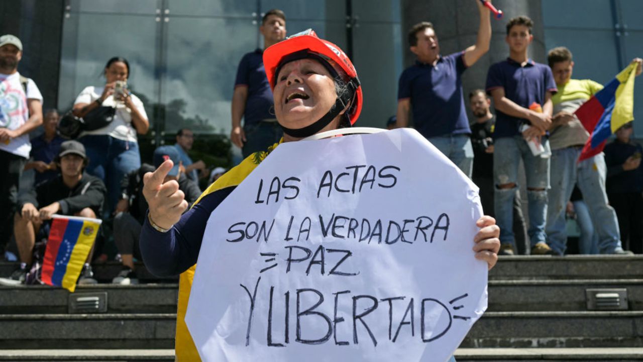 A woman holds a sign that read in Spanish 'The voting records are the real peace and freedom' during a rally called by presidential candidate Edmundo Gonzalez Urrutia and opposition leader Maria Corina Machado, in front of the United Nations headquarters in Caracas on July 30, 2024. Venezuela braced for new demonstrations on July 30, after four people died and dozens were injured when the authorities broke up protests against President Nicolas Maduro's claim of victory in the country's hotly disputed weekend election. (Photo by YURI CORTEZ / AFP) (Photo by YURI CORTEZ/AFP via Getty Images)