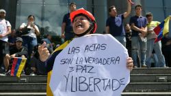 A woman holds a sign that read in Spanish 'The voting records are the real peace and freedom' during a rally called by presidential candidate Edmundo Gonzalez Urrutia and opposition leader Maria Corina Machado, in front of the United Nations headquarters in Caracas on July 30, 2024. Venezuela braced for new demonstrations on July 30, after four people died and dozens were injured when the authorities broke up protests against President Nicolas Maduro's claim of victory in the country's hotly disputed weekend election. (Photo by YURI CORTEZ / AFP) (Photo by YURI CORTEZ/AFP via Getty Images)