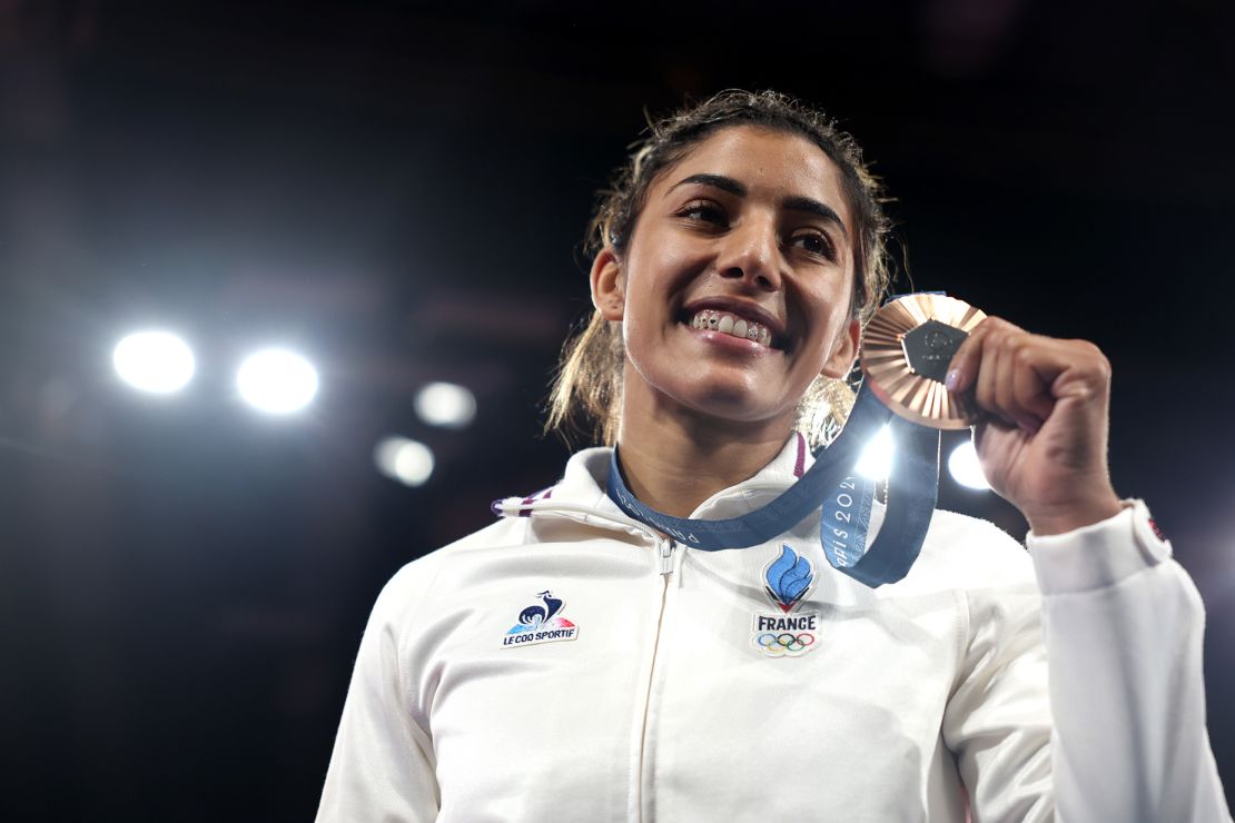 France's judo bronze medalist Shirine Boukli smiled and showed her tooth gems on the podium during the women 48kg medal ceremony on July 27.