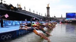 Athletes dive into the Seine river to start the swimming stage of the men's individual triathlon at the Paris 2024 Olympic Games in central Paris on July 31, 2024. (Photo by Anne-Christine POUJOULAT / AFP)