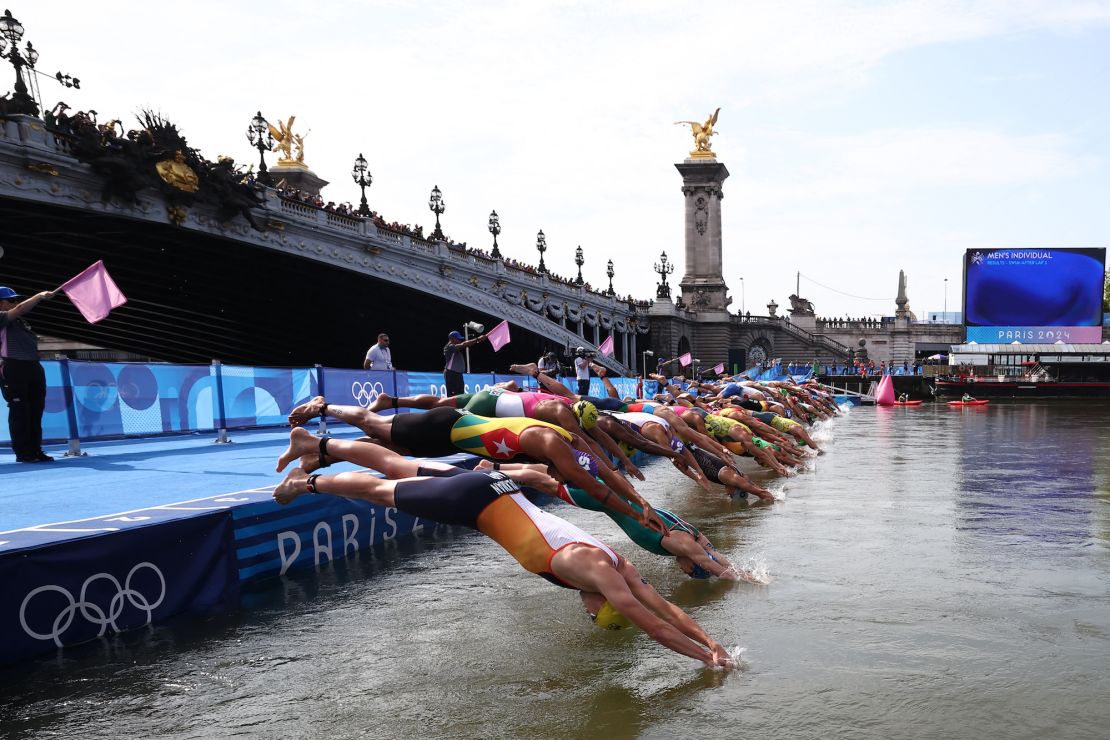 Athletes dive into the Seine river to start the swimming stage of the men's individual triathlon at the Paris 2024 Olympic Games in central Paris on July 31, 2024.