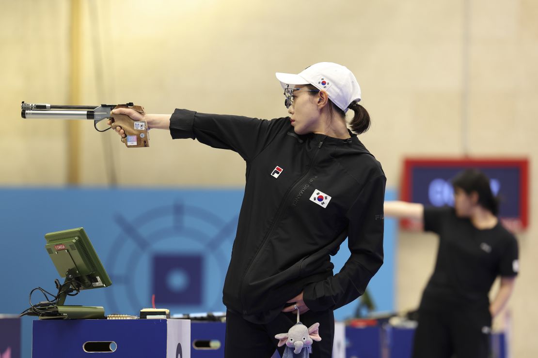 South Korean Olympic sharpshooter took silver in the 10-meter air pistol event, wearing a pair of cyborg-worthy shooting glasses, Black Fila jacket, Sauer shoes and a stuffed toy elephant.