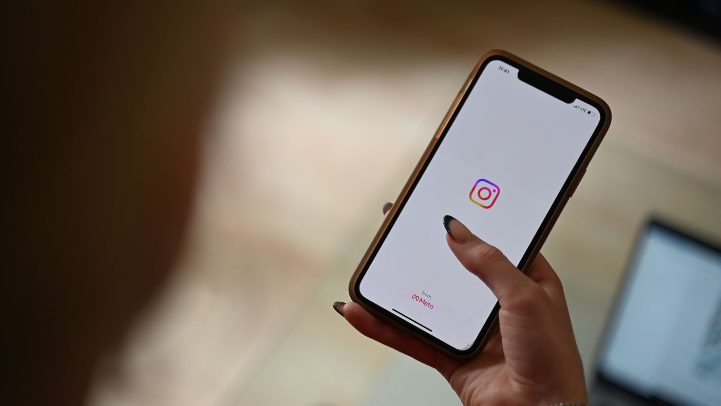 A woman opens Instagram on her smartphone.