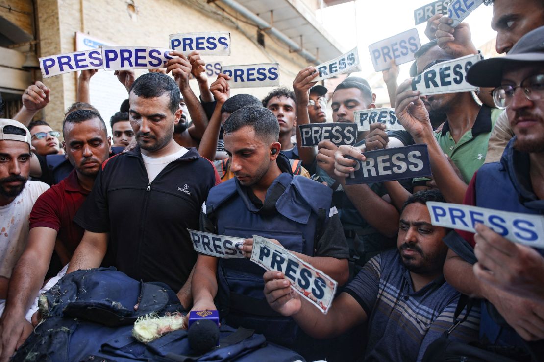 Mourners and colleagues holding 'press' signs surround the body of Al-Jazeera Arabic journalist Ismail Al-Ghoul on July 31.