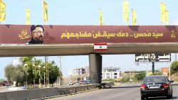 Yellow Hezbollah flags are erected along with a banner showing assassinated Hezbollah commander Fuad Shukr, along a walkway across the Sidon-to-Tyre highway, in southern Lebanon on August 2, 2024. The body of Shukr was recovered from the rubble of a July 30 Israeli strike on south Beirut that also killed five civilians, three women and two children, and injured dozens, according to Lebanon's health ministry, as fears mounted of a wider conflict in the region.