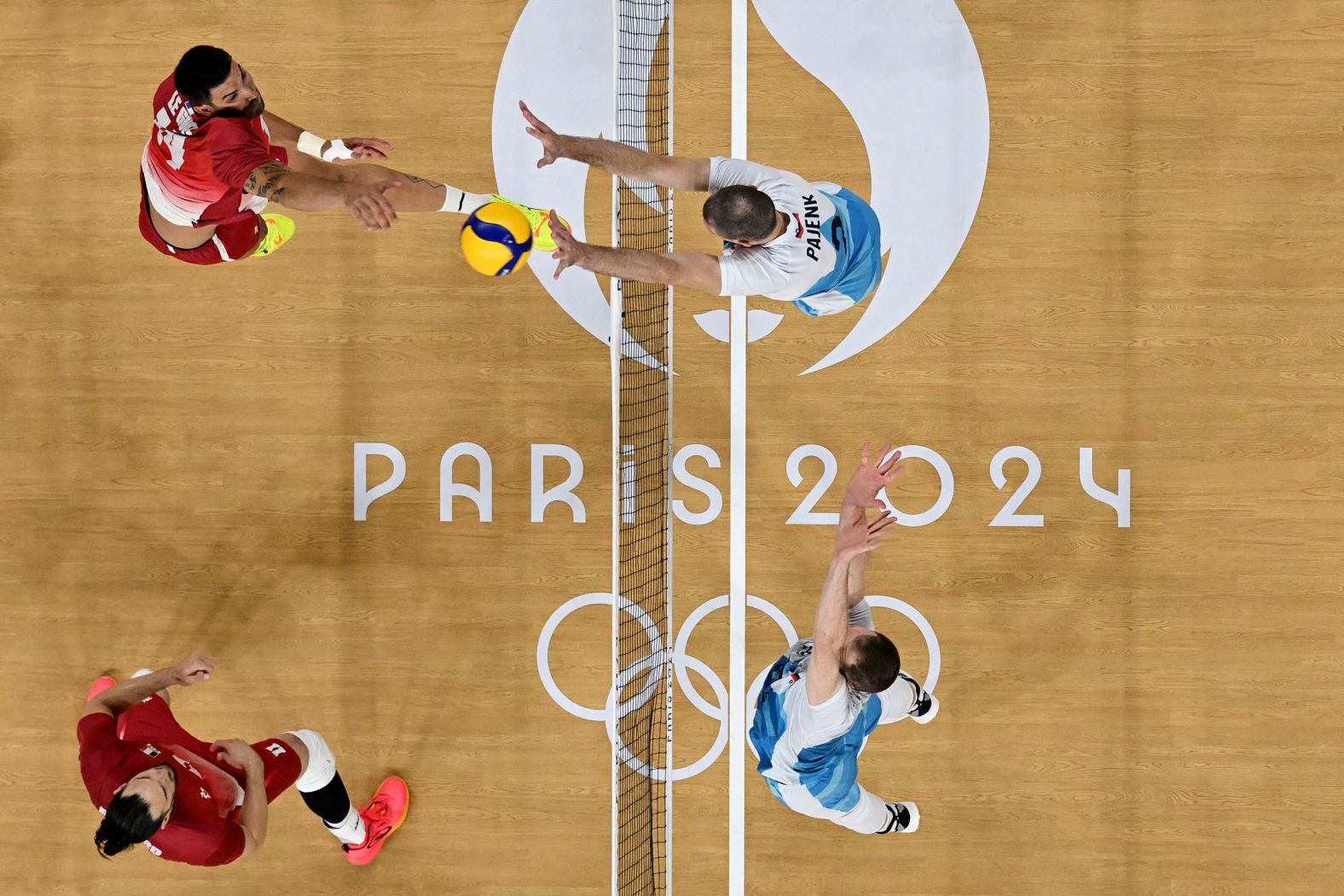 France's Nicolas Le Goff tries to hit the ball past Slovenia's Alen Pajenk during a volleyball match on August 2.