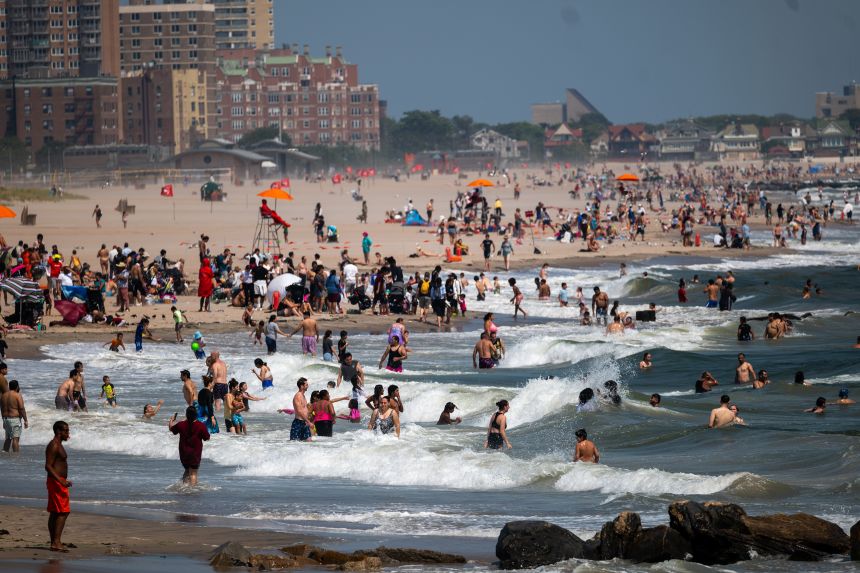 People entering rough sea at Coney Island in New York City in July 2024.