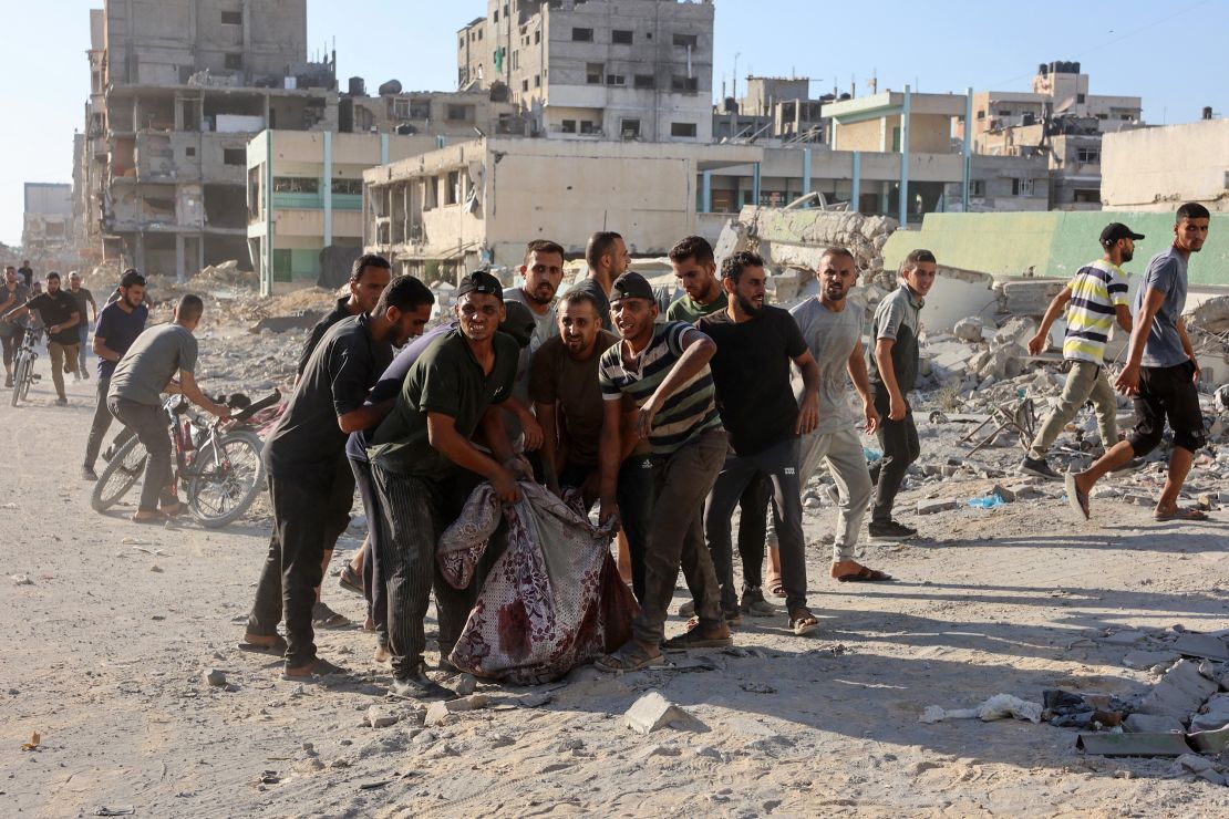 Palestinians evacuate a body pulled from the rubble following Israeli bombardment which hit a school complex, including the Hamama and al-Huda schools, in the Sheikh Radwan neighbourhood in the north of Gaza City on August 3, 2024.