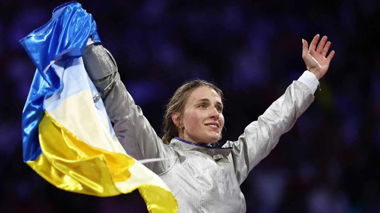 Ukraine's Olga Kharlan celebrates with her country's flag after winning in the women's sabre team gold medal bout between South Korea and Ukraine during the Paris 2024 Olympic Games at the Grand Palais in Paris, on August 3, 2024.