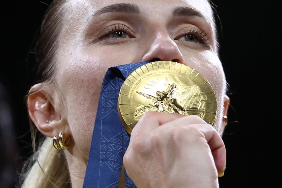 Kharlan celebrates her women's sabre team gold on the podium.