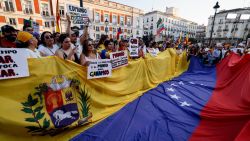 Demonstrators hold a giant national flag of Venezuela during a protest against Venezuelan President Nicolas Maduro's disputed victory in the country's Presidential elections, at Puerta del Sol, Madrid, on August 3, 2024. (Photo by OSCAR DEL POZO / AFP) (Photo by OSCAR DEL POZO/AFP via Getty Images)