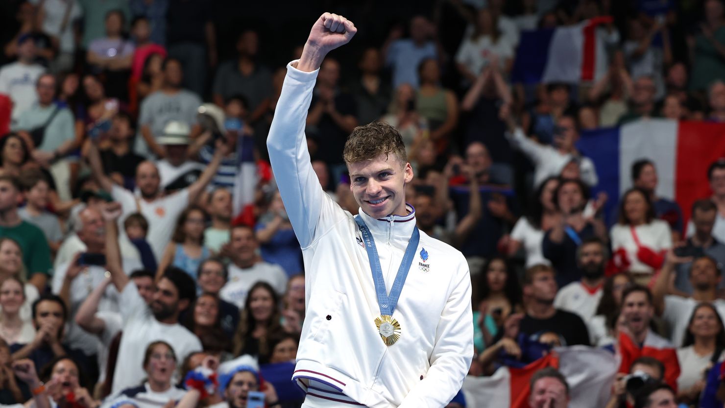 NANTERRE, FRANCE - JULY 31: Gold Medalist Leon Marchand of Team France celebrates on the podium during the Swimming medal ceremony after the Men's 200m Breaststroke Final on day five of the Olympic Games Paris 2024 at Paris La Defense Arena on July 31, 2024 in Nanterre, France. (Photo by Quinn Rooney/Getty Images)