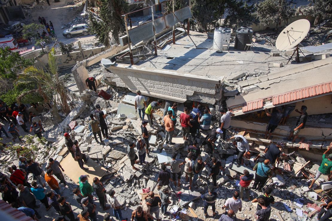 People and emergency crews look for survivors following Israeli bombardment on the Al-Nassr school that houses displaced Palestinians, West of Gaza city, on August 4, 2024.