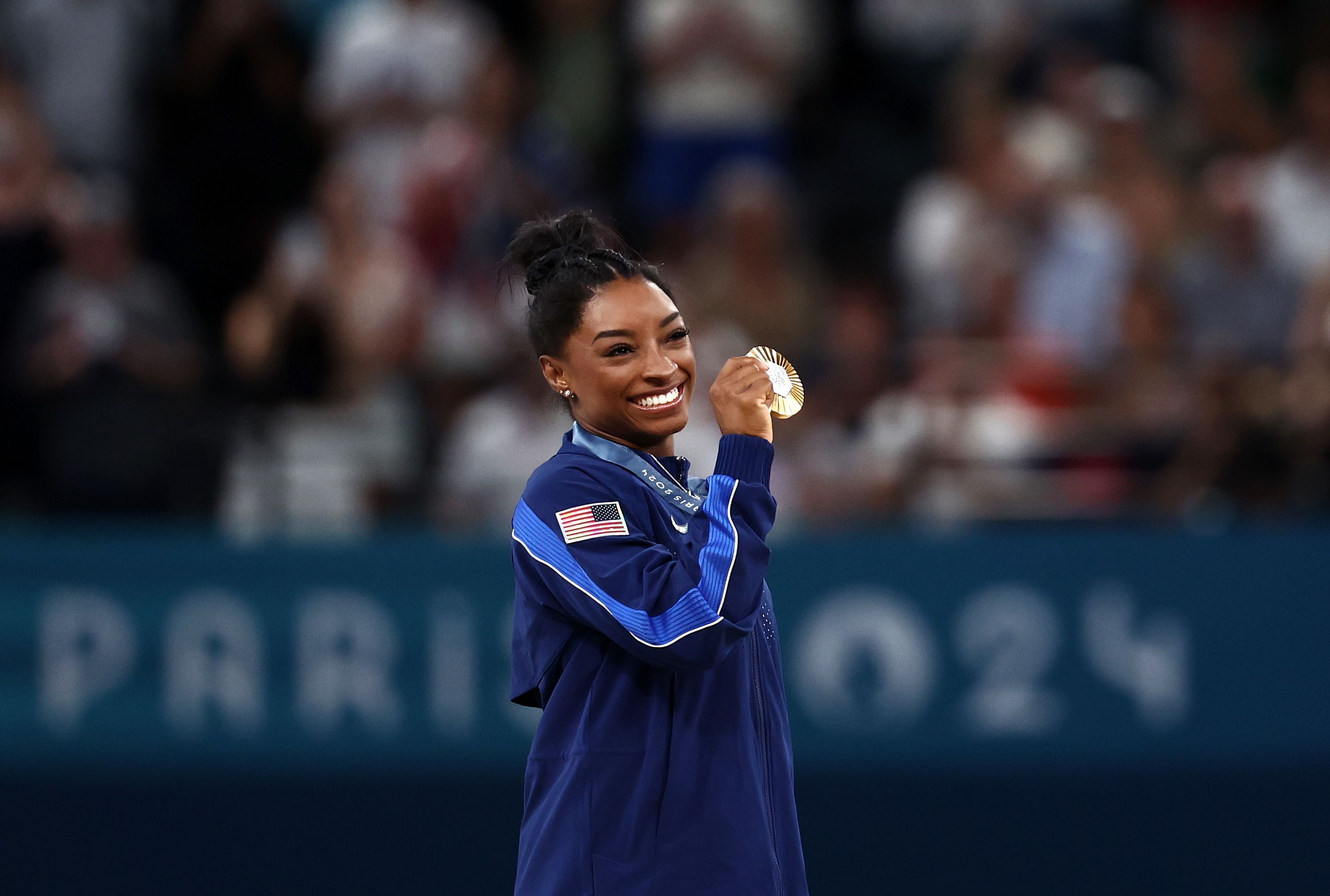 Biles poses with her gold medal after the event.