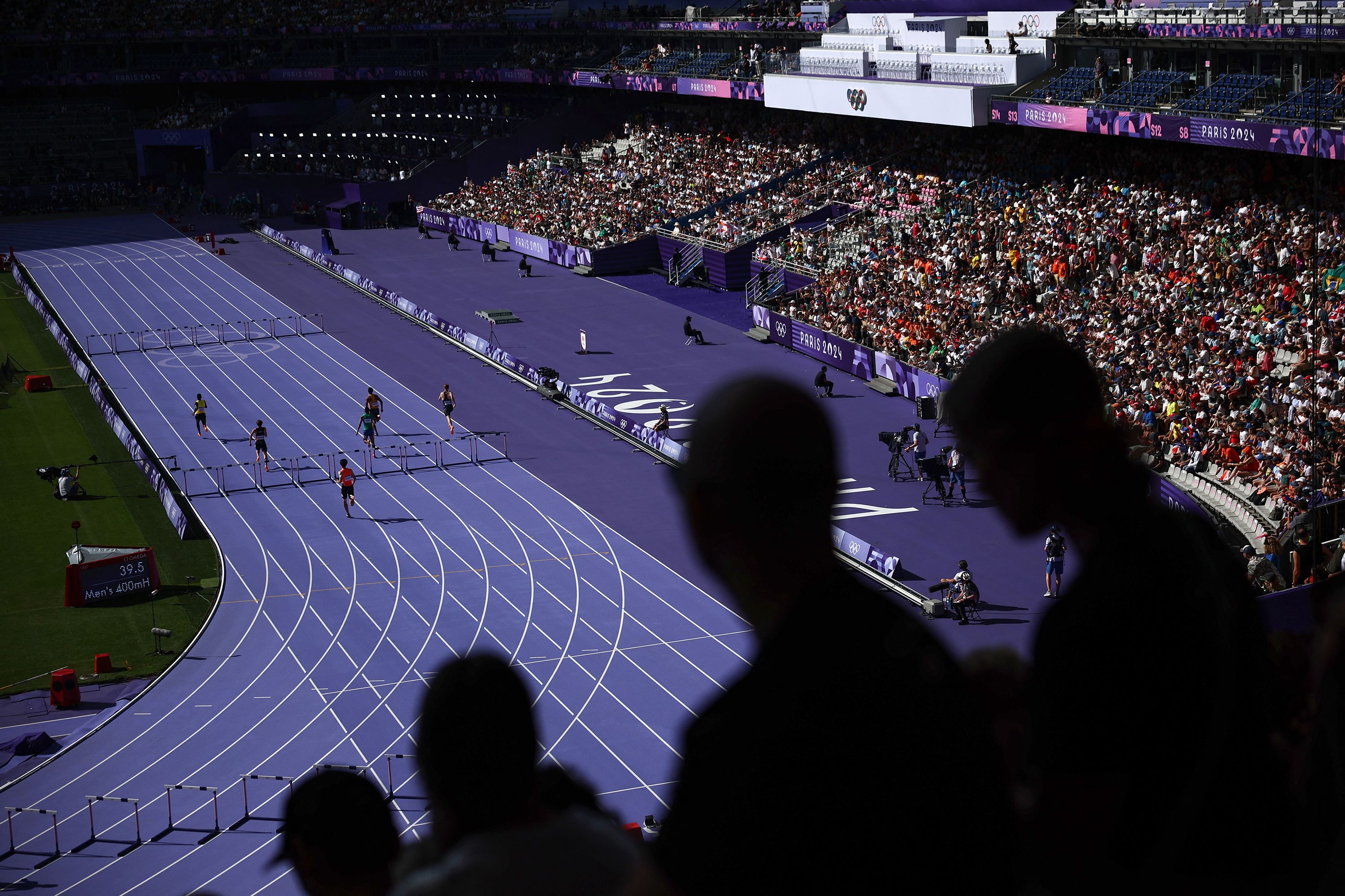 Athletes run the 400-meter hurdles on August 5.