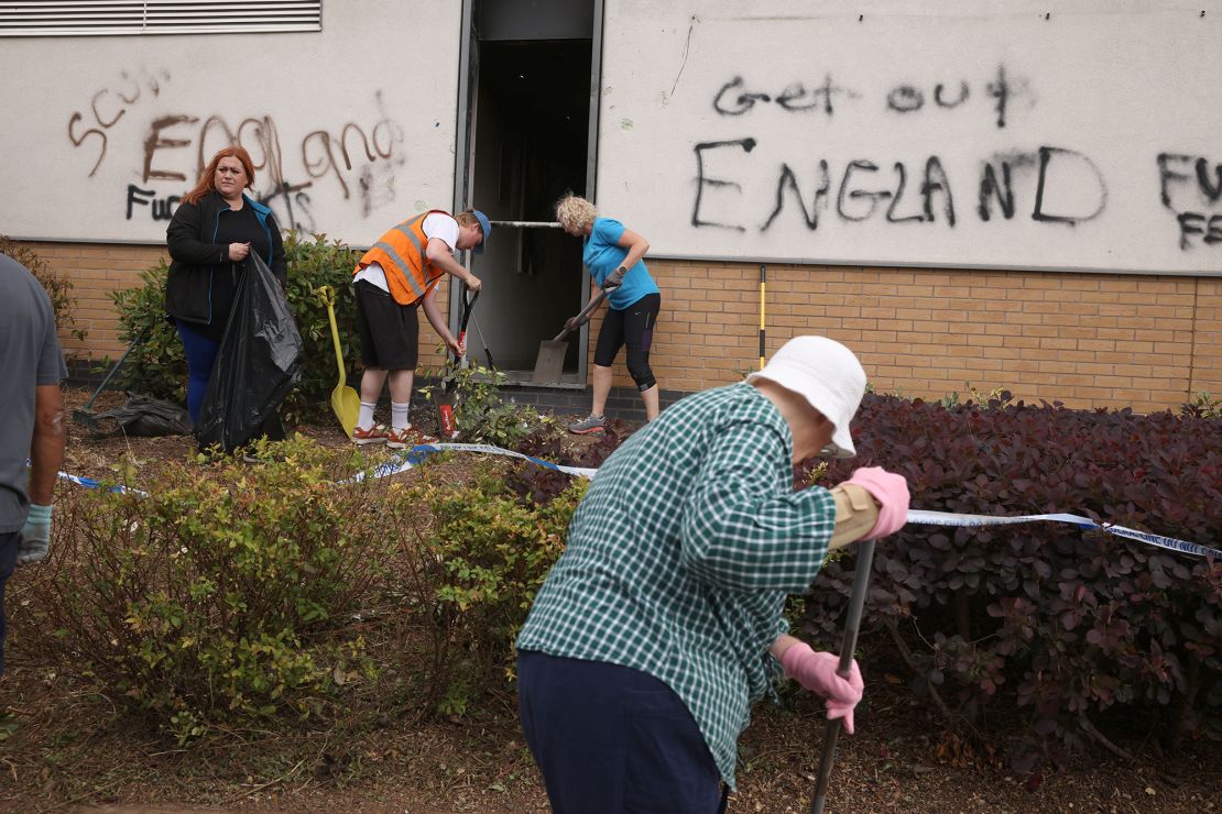 People clean up debris outside a hotel in Tamworth, after it was targeted during the wave of far-right attacks at the weekend.