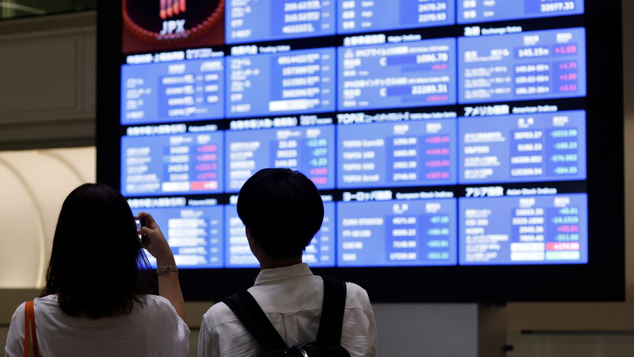 Visitors in front of an electric stock board at the Tokyo Stock Exchange (TSE) in Tokyo, Japan, on Tuesday, August 6, 2024.