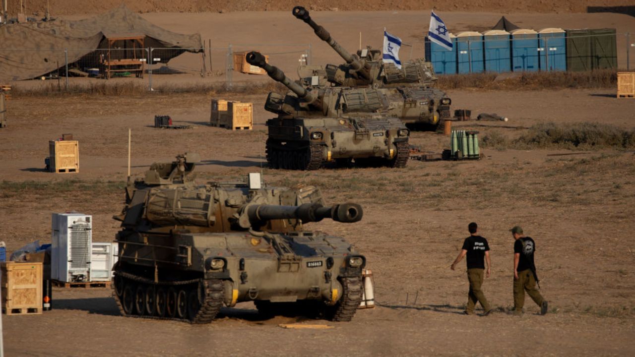SOUTHERN ISRAEL, ISRAEL - AUGUST 7: Israeli soldiers walk by artillery units near the border with the Gaza Strip on August 7, 2024 in Southern Israel, Israel. Ten months has ed since the Oct. 7th Hamas-led attack on southern Israel, which sparked a devastating war in Gaza that threatens to spill into the wider region. (Photo by Amir Levy/Getty Images)
