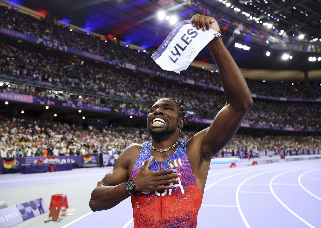 US track star Noah Lyles of Team celebrates winning the gold medal in the men's 100m final. He accessorized with necklace that he's worn to previous races and pearls woven into his hair.