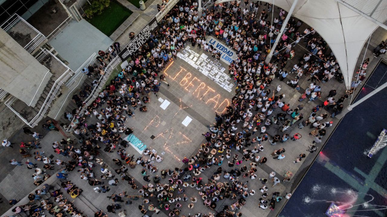 TOPSHOT - Aerial view shows people surrounding lit candles forming the words 'Freedom and Peace' during a vigil called by the opposition demanding freedom for political prisoners arrested during protest following the contested re-election of Venezuelan President Nicolas Maduro in Caracas, August 8, 2024. Venezuela's opposition warned of a potential mass exodus of migrants if President Nicolas Maduro remains in power following his contested reelection, with the US calling on the strongman not to arrest protest leaders. (Photo by Hirsaid GOMEZ / AFP) (Photo by HIRSAID GOMEZ/AFP via Getty Images)