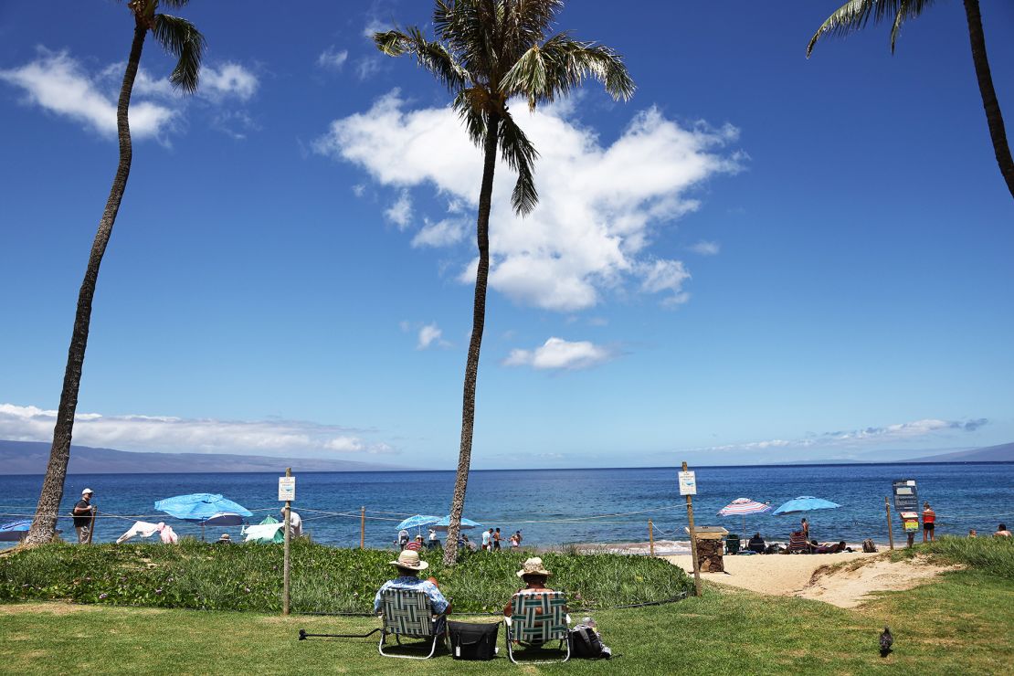 People gather along Kaanapali Beach on August 5, 2024, near Lahaina. In the first half of 2024, Maui saw a 23.8% decrease in visitor arrivals from the same period last year. That's slowing down the economic recovery on the island.