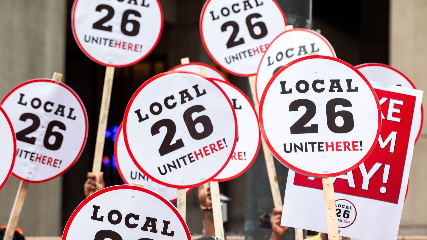 Boston, MA - August 8: People hold UNITE HERE Local 26 signs at a press conference after a strike authorization vote by UNITE HERE Local 26. Date created: August 08, 2024