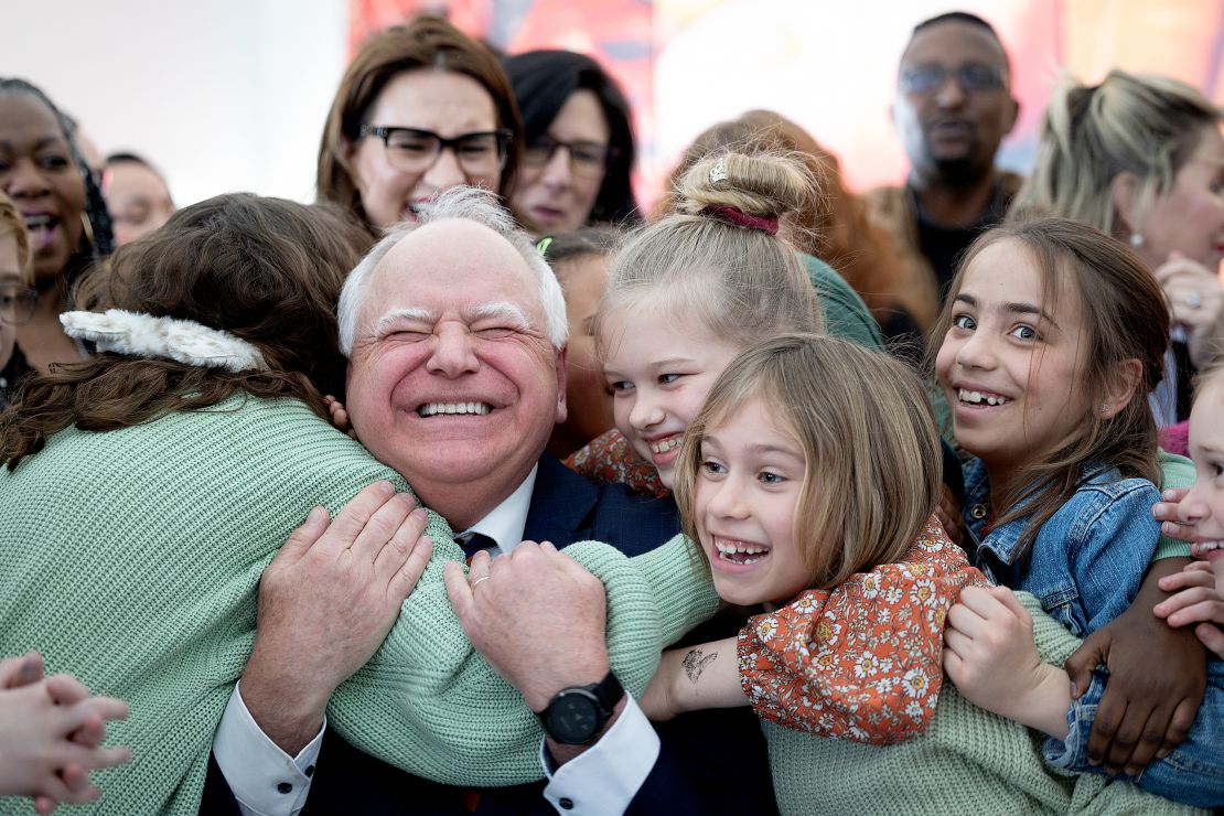 Tim Walz recibe un abrazo de los estudiantes de la escuela primaria Webster en Minneapolis después de firmar una ley que garantiza comidas escolares gratuitas para todos los estudiantes en las escuelas públicas y autónomas de Minnesota el 17 de marzo de 2023.