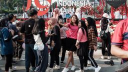 People take selfies in front of a 79th Independence Day sign in Jakarta, Indonesia, on August 11, 2024. Indonesia top the Global Flourishing Study's rankings this year.