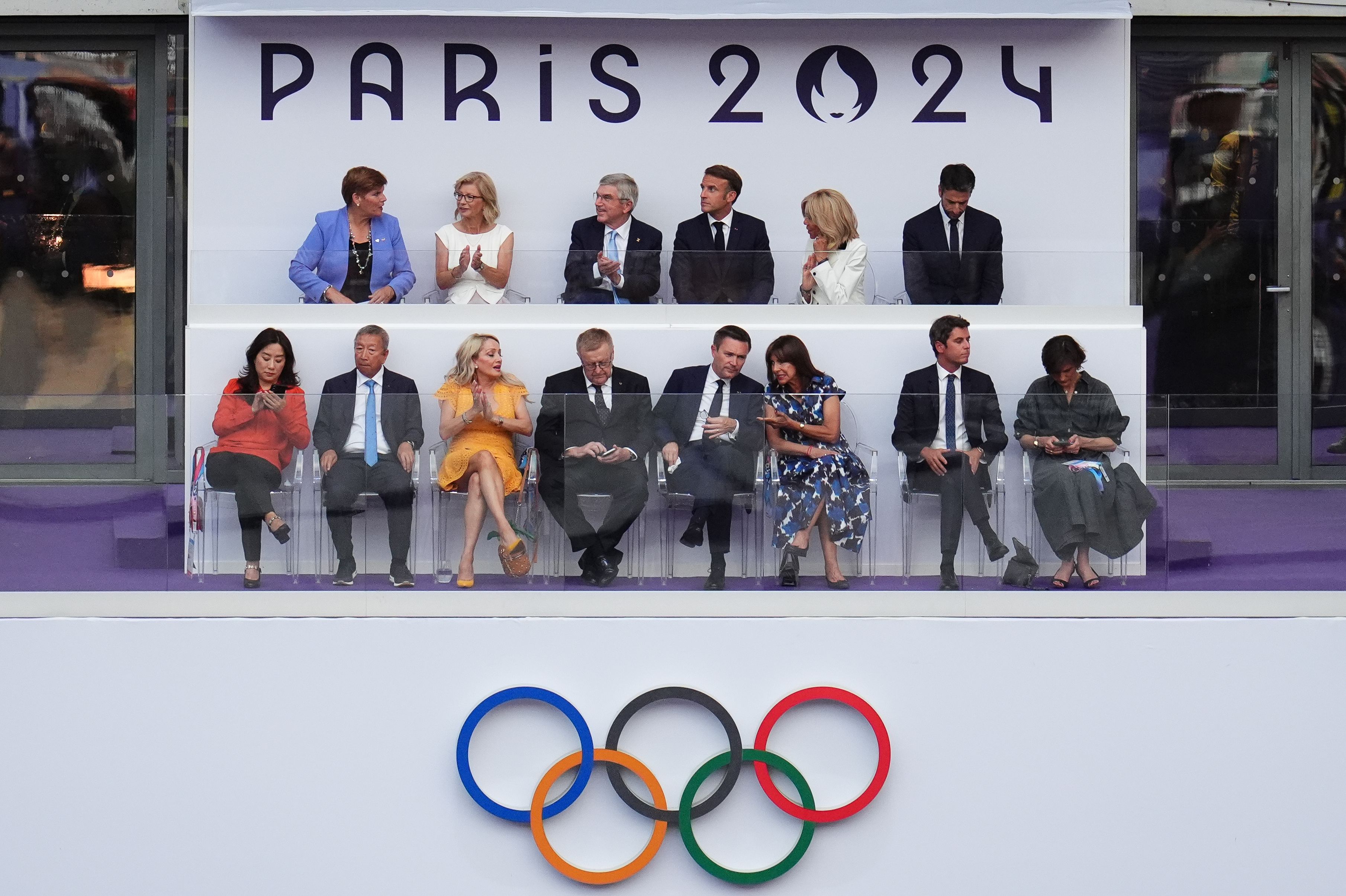 French President Emmanuel Macron, third from right on the top row, sits between his wife, Brigitte, and International Olympic Committee President Thomas Bach at the Stade de France.