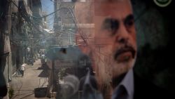 BEIRUT, LEBANON - AUGUST 08: People are reflected in a window displaying a poster of newly appointed Hamas leader Yahya Sinwar in the Palestinian camp of Bourj al-Barajneh on August 08, 2024 in Beirut Lebanon. The recent assassination of a Hezbollah military commander in Lebanon, as well as the killing of the political leader of Hamas in Iran, has heightened concerns of a wider regional war between Israel and Iran-backed enemies like Hezbollah. Israel and Hezbollah have traded regular cross-border fire since Oct. 7, although both sides have seemed to calculate their attacks to avoid all-out war. (Photo by Chris McGrath/Getty Images)