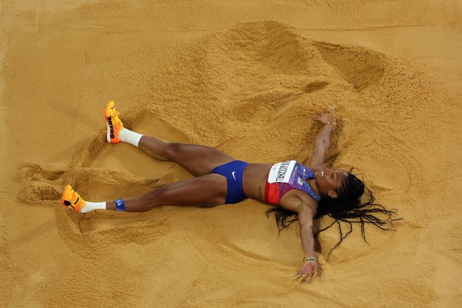 American long jumper Tara Davis-Woodhall celebrates in the sand <a >after winning gold</a> on August 8.