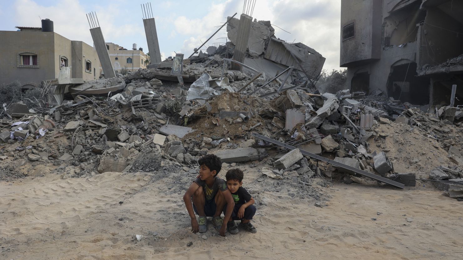 TOPSHOT - Children sit in front of the house of deputy chief of the People's Front for the Liberation of Palestine, Jamil Mazhar, which was targeted in overnight Israeli strikes on Nusseirat in the Central Gaza Strip on August 12, 2024, amid the ongoing conflict between Israel and the Palestinian militant group Hamas. (Photo by Eyad BABA / AFP) (Photo by EYAD BABA/AFP via Getty Images)