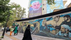 TOPSHOT - People walk past a billboard showing a portrait of newly appointed Hamas leader Yahya Sinwar (top) next to Palestine Square in the Tehran on August 12, 2024. (Photo by ATTA KENARE / AFP) (Photo by ATTA KENARE/AFP via Getty Images)