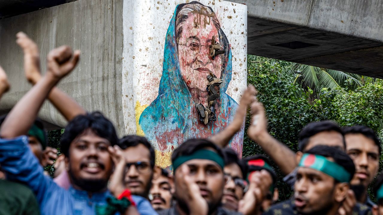 Students chant slogans near a vandalised mural of Bangladesh's ousted Prime Minister Sheikh Hasina, during a protest demanding accountability and trial against Hasina, near Dhaka University in the capital on August 12, 2024.