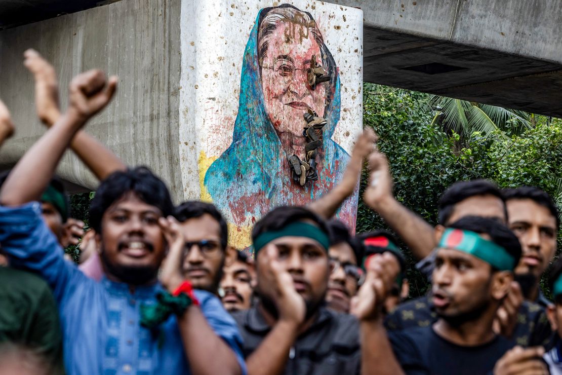 Students chant slogans near a vandalised mural of Bangladesh's ousted Prime Minister Sheikh Hasina, during a protest demanding accountability and trial against Hasina in the capital in August 2024.