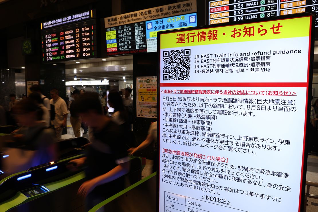 Een bericht op een treinstation kondigt aan dat treinen met lagere snelheid zullen rijden na een aardbevingswaarschuwing op 9 augustus 2024 in Tokio.