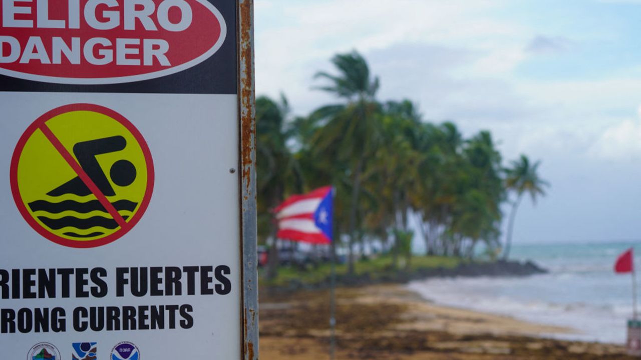 A warning sign reading "Danger, No Swimming" is seen on the beach in Luquillo, Puerto Rico on August 13, 2024 as Tropical Storm Ernesto approaches. Ernesto is about 300 miles (480kms) east southeast of Puerto Rico, according to the US National Hurricane Center and predicts the storm will reach the island by late August 13. (Photo by Jaydee Lee SERRANO / AFP) (Photo by JAYDEE LEE SERRANO/AFP via Getty Images)