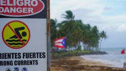 A warning sign reading "Danger, No Swimming" is seen on the beach in Luquillo, Puerto Rico on August 13, 2024 as Tropical Storm Ernesto approaches. Ernesto is about 300 miles (480kms) east southeast of Puerto Rico, according to the US National Hurricane Center and predicts the storm will reach the island by late August 13. (Photo by Jaydee Lee SERRANO / AFP) (Photo by JAYDEE LEE SERRANO/AFP via Getty Images)