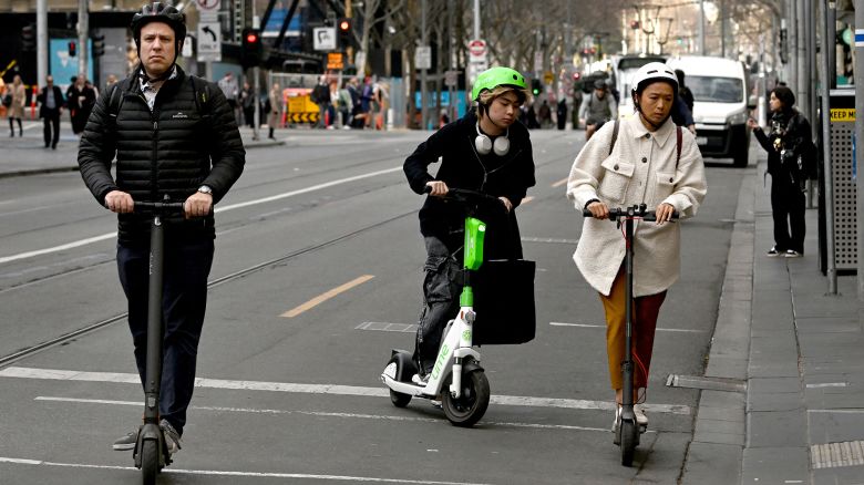 People ride e-scooters in Melbourne's central business district (CBD) on August 14, 2024. Melbourne has become the latest city to announce a ban on rental e-scooters, abruptly moving to end a trial contract with two firms after a community revolt. (Photo by William WEST / AFP) (Photo by WILLIAM WEST/AFP via Getty Images)