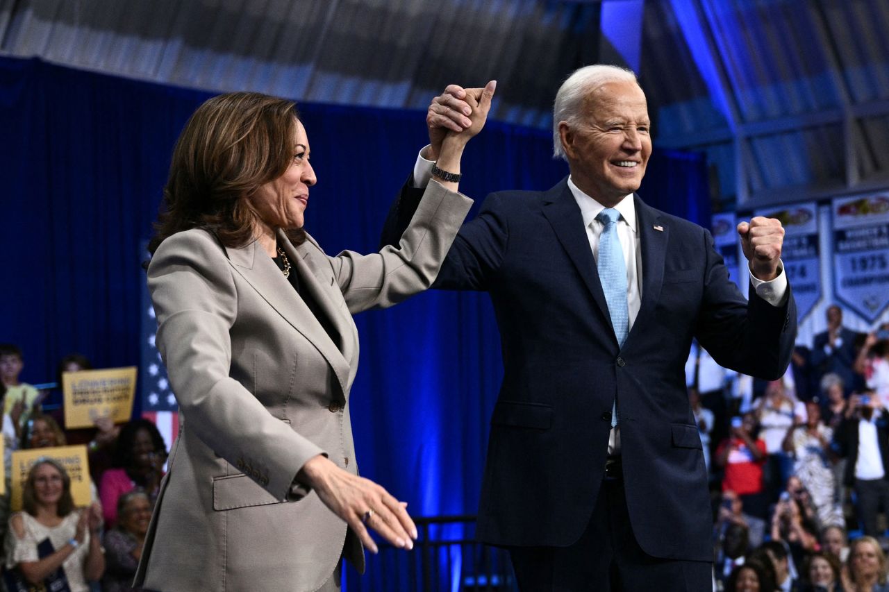 President Joe Biden and Vice President Kamala Harris clasp and raise their hands after speaking at Prince George's Community College in Largo, Maryland, on August 15.