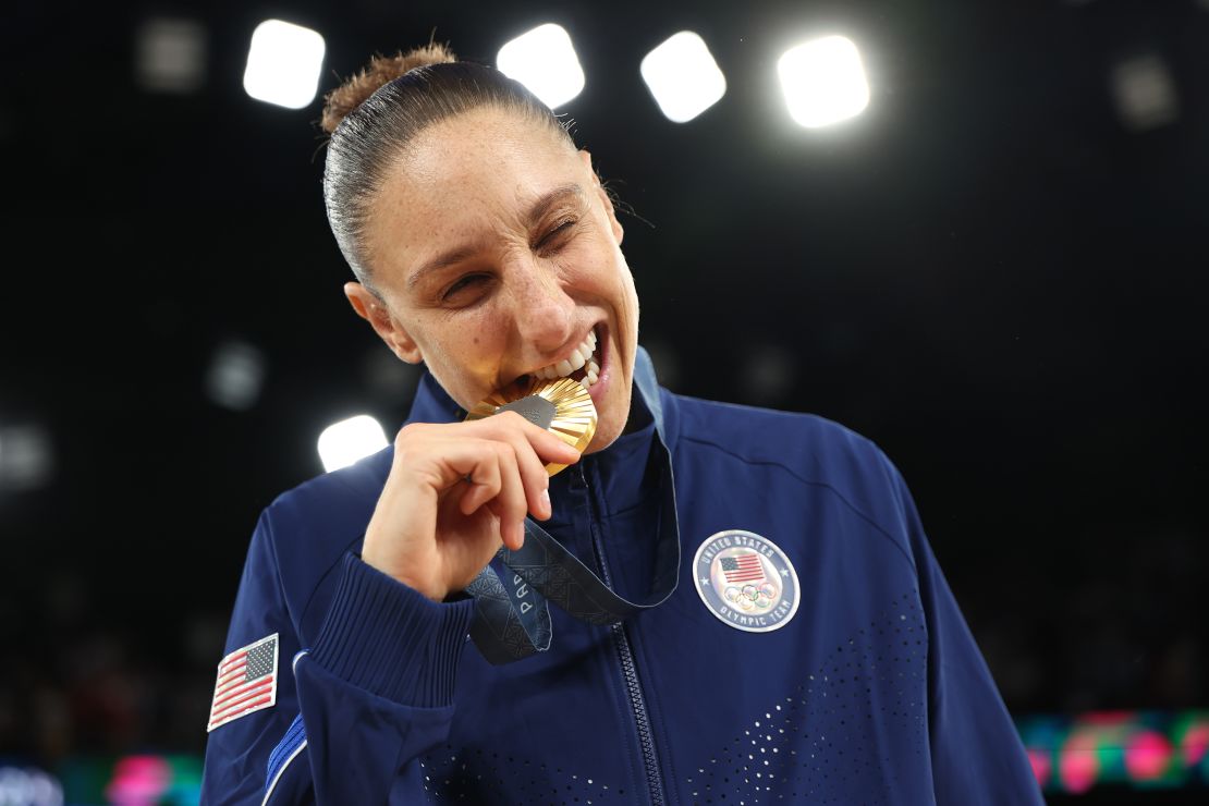 PARIS, FRANCE - AUGUST 11: Gold medalist Diana Taurasi of Team United States bites her medal during the Women's basketball medal ceremony on day sixteen of the Olympic Games Paris 2024 at Bercy Arena on August 11, 2024 in Paris, France. (Photo by Gregory Shamus/Getty Images)