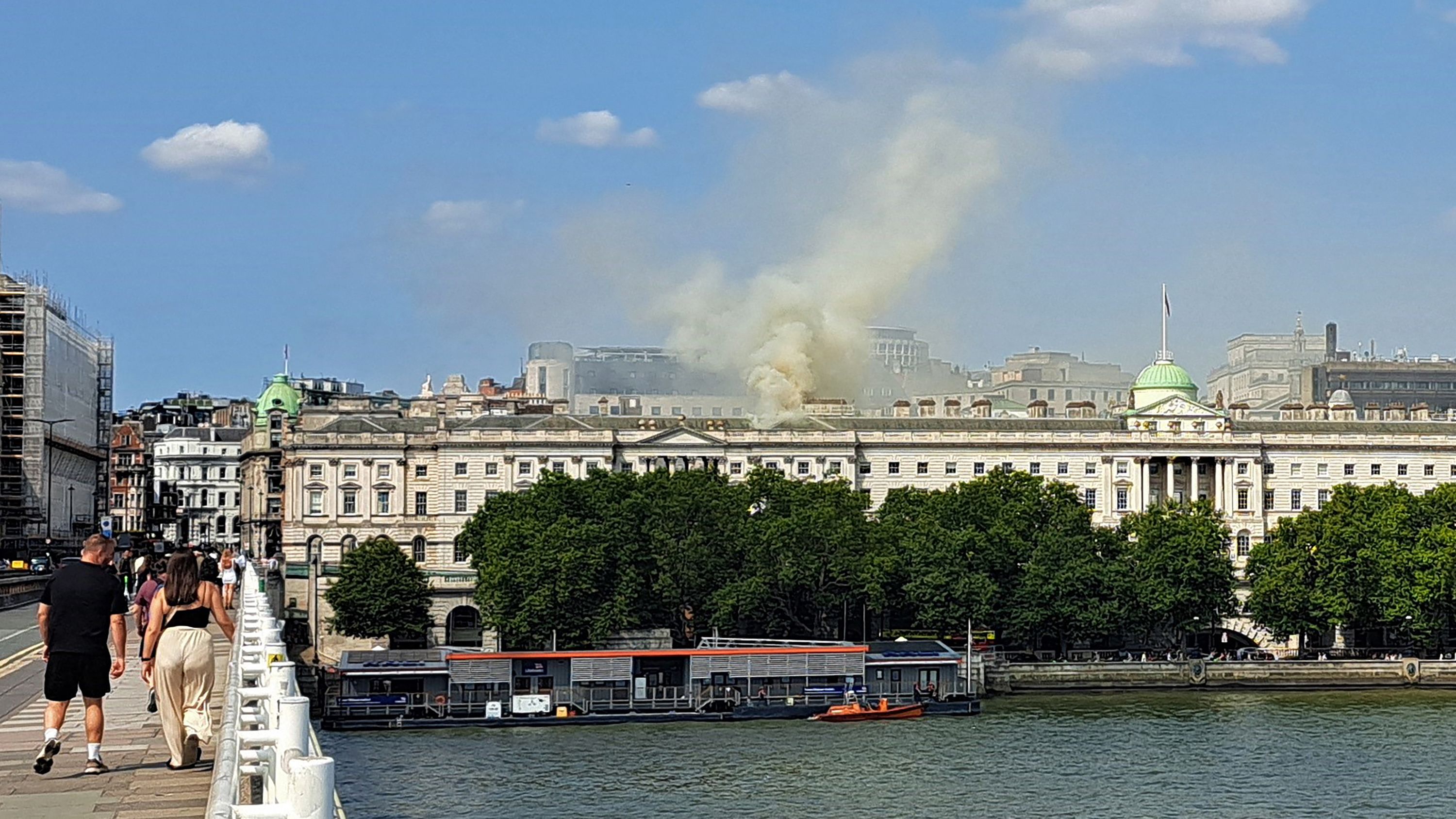 Viewed from Waterloo Bridge, smoke rises from a fire in the roof of Somerset House beside the River Thames in London.