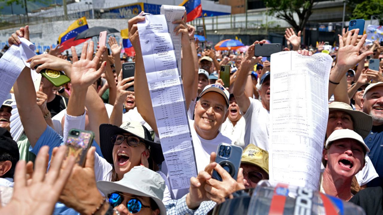 People shout slogans and show voting records during a protest called by the opposition for election 'victory' to be recognised, in Caracas on August 17, 2024. Venezuela's opposition and regime supporters will vie for the streets of Caracas in competing demonstrations amid a political crisis sparked by a disputed election where both President Nicolas Maduro and his rival Edmundo Gonzalez Urrutia -backed by opposition leader Maria Corina Machado- have claimed victory. (Photo by Juan BARRETO / AFP) (Photo by JUAN BARRETO/AFP via Getty Images)