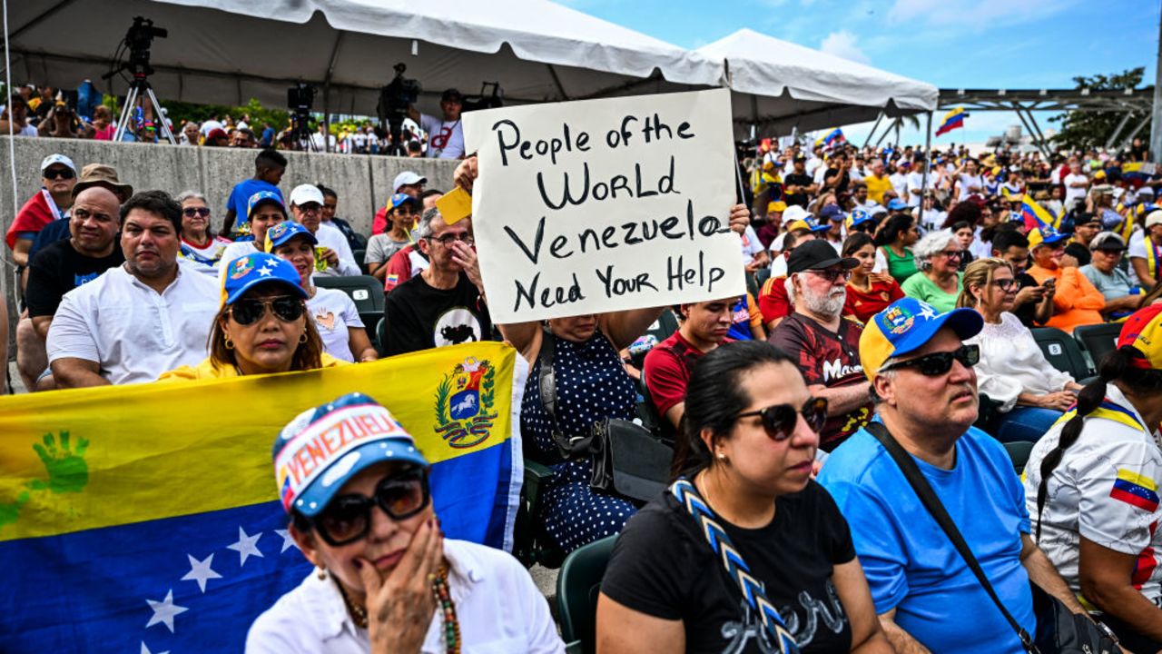 A demonstrator holds a sign reading "People of the World, Venezuela Needs You" as they take part in the "Protest for Truth" rally called by the Venezuelan opposition to demand that the Venezuelan government recognize Edmundo Gonzalez Urrutia's victory in the presidential elections, in Miami, Florida, August 17, 2024. Venezuelan opposition leader Maria Corina Machado urged supporters August 16, 2024, to "keep up the fight" on the eve of protests called against the election victory claimed by strongman Nicolas Maduro but widely rejected at home and abroad. Machado had called for fresh demonstrations in more than 300 cities in Venezuela and abroad, what she called a "Protest for the Truth." (Photo by CHANDAN KHANNA / AFP) (Photo by CHANDAN KHANNA/AFP via Getty Images)