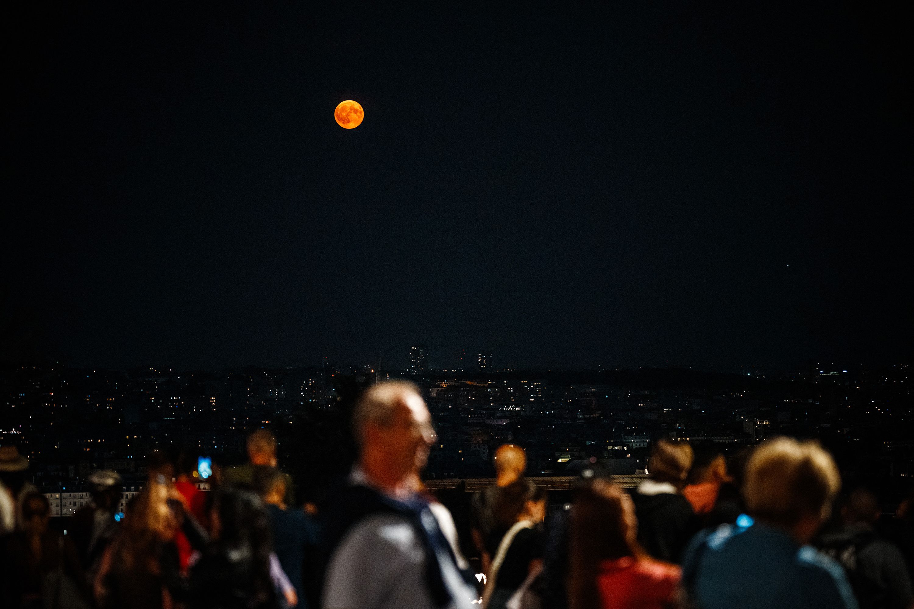 People watch the super blue moon in Paris.