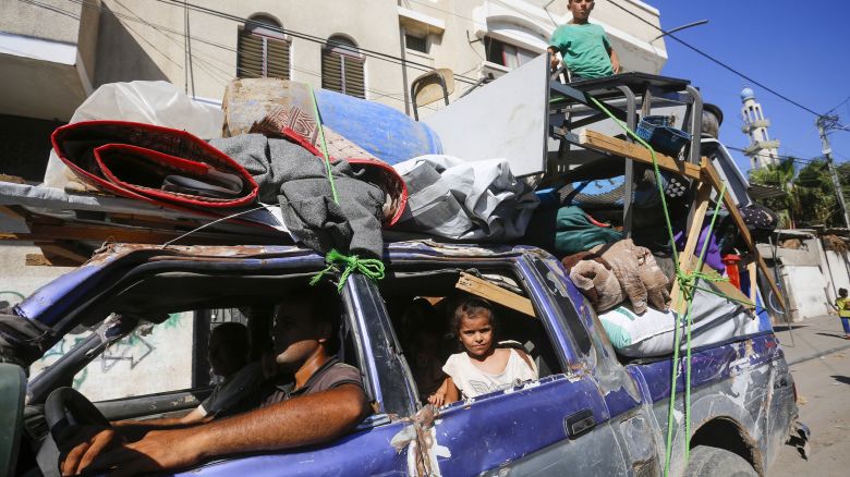 DEIR AL-BALAH, GAZA - AUGUST 21: Palestinians, carrying their belongings, are on their way to migrate for safer areas following the Israeli army's warning for the evacuation of Abu Areef and Al-Mazra areas in Deir al-Balah, Gaza on August 21, 2024. (Photo by Ashraf Amra/Anadolu via Getty Images)