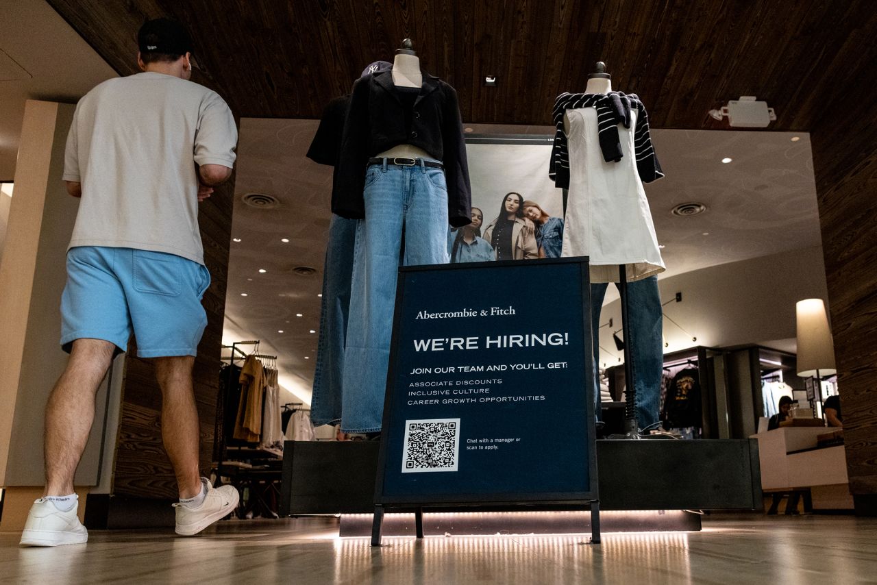 A shopper walks past a hiring sign displayed in front of Abercrombie & Fitch at the Tysons Corner Center mall on August 22 in Tysons, Virginia.