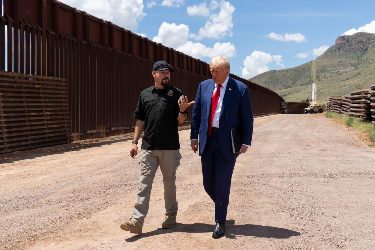 Donald Trump walks with National Border Patrol Council board member Art Del Cueto along a section of the US-Mexico border south of Sierra Vista, Arizona on August 22.