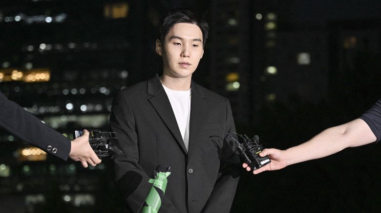 South Korean singer Suga of K-pop mega group BTS arrives at a police station in the Yongsan district of Seoul on August 23, 2024 for questioning after being charged with riding an electric scooter while under the influence late night on August 6. (Photo by Anthony WALLACE / AFP) (Photo by ANTHONY WALLACE/AFP via Getty Images)