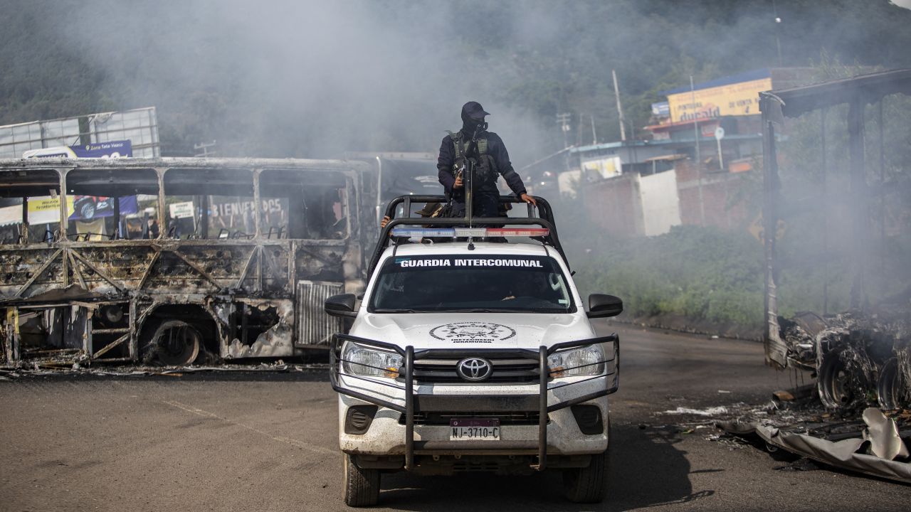 A police patrol crosses a barricade set up by residents to pressure for the release of seven indigenous police officers allegedly kidnapped by hitmen from organised crime in Santiago Tangamandapio, Michoacan State, Mexico on August 23, 2024. According to the Prosecutor's Office, the community police officers were kidnapped on August 20 and rescued today amid protests by residents who burned vehicles and blocked roads to pressure their release. (Photo by Enrique Castro / AFP) (Photo by ENRIQUE CASTRO/AFP via Getty Images)